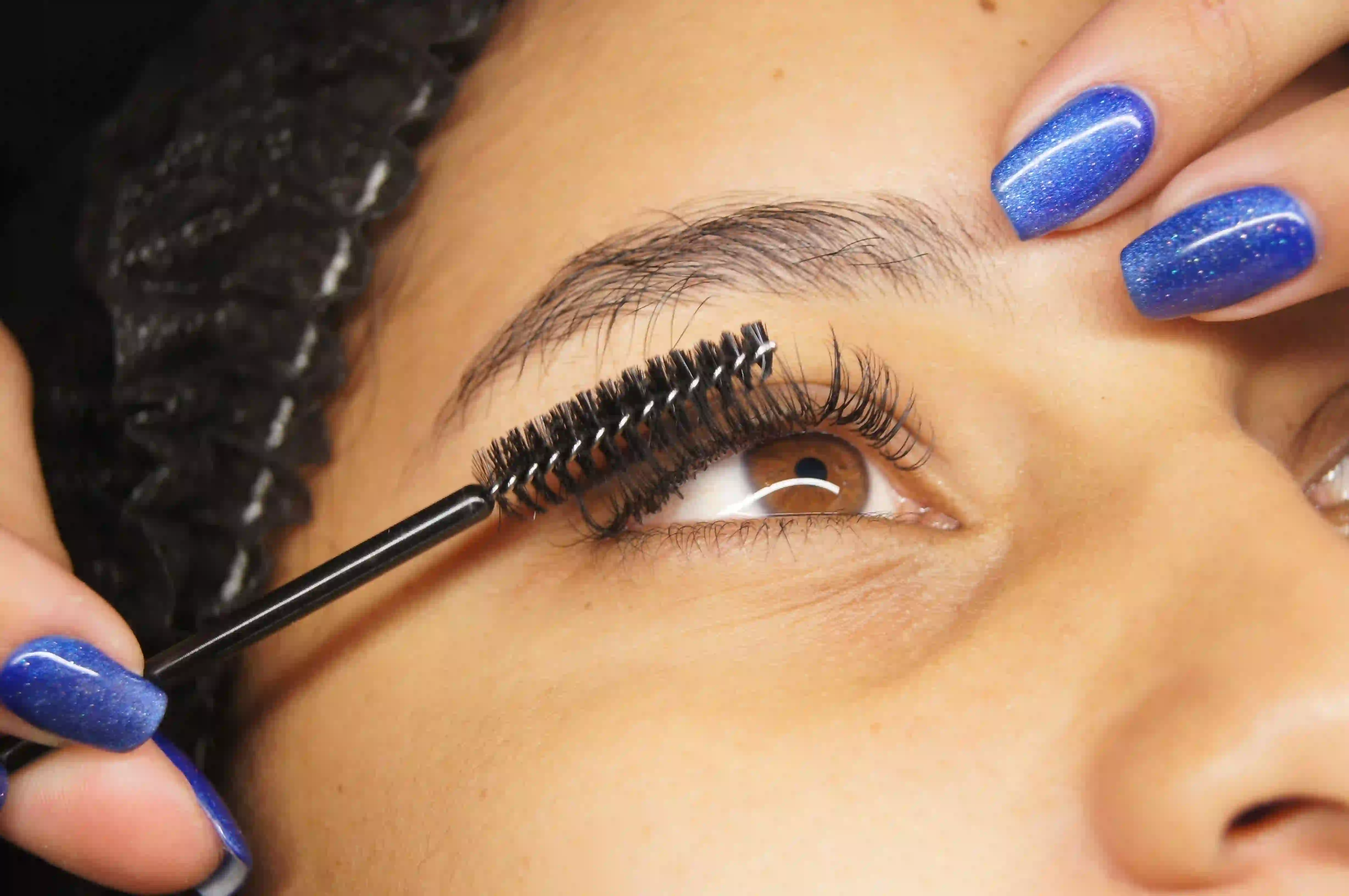 Technician reviewing lash health during a client consultation before eyelash tinting