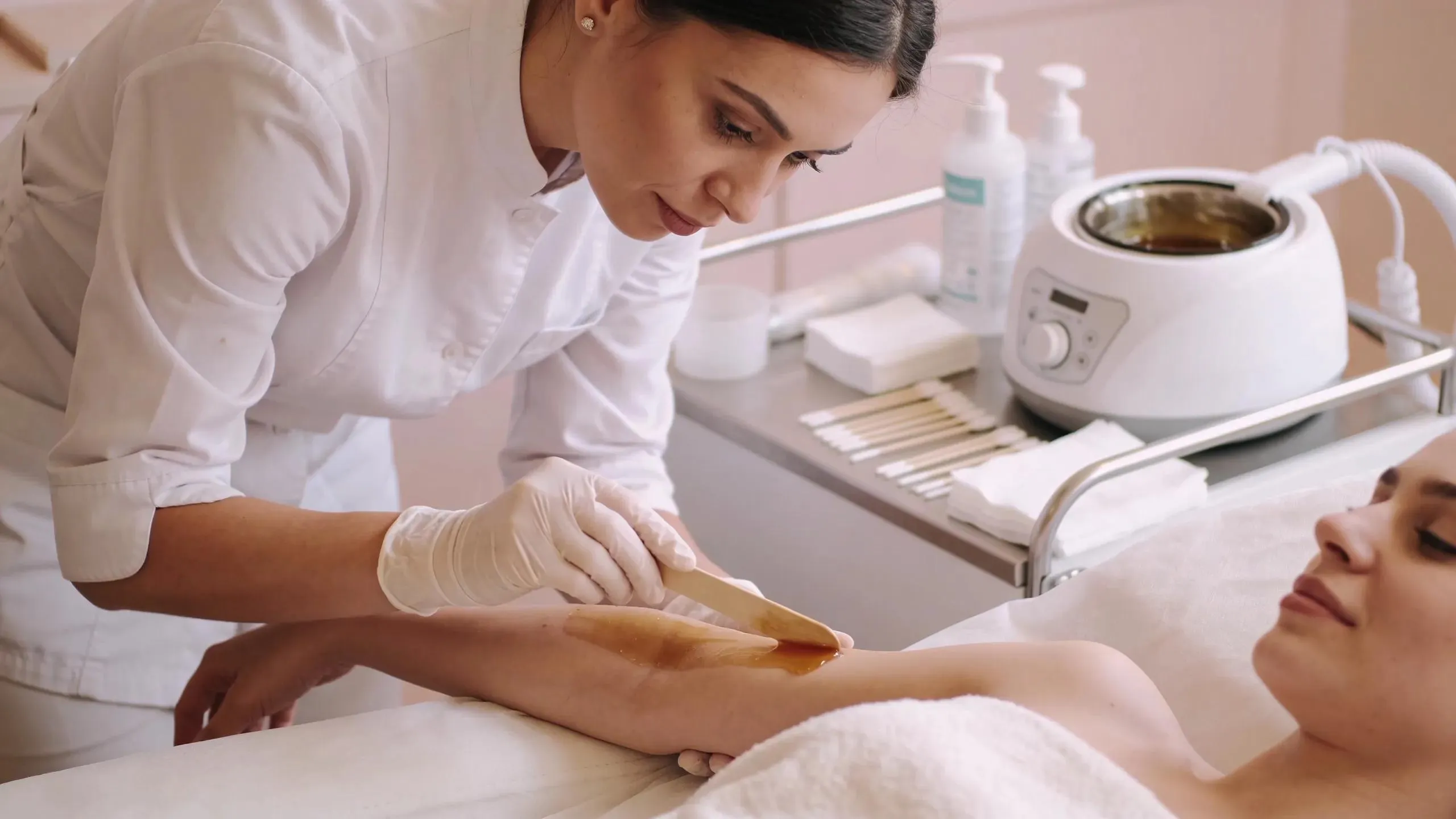 Professional esthetician preparing for a waxing session, emphasizing hygiene and comfort in waxing salons