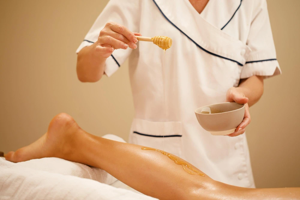a professional esthetics training room is illuminated by soft, focused lighting, featuring a serene waxing station with neatly arranged tools, emphasizing the importance of expertise and ongoing education in providing a comfortable client experience.